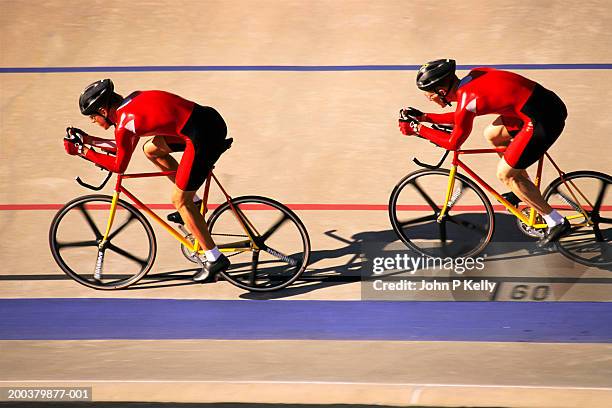 two racing cyclists in velodrome, side view (blurred motion) - track cycling stock-fotos und bilder