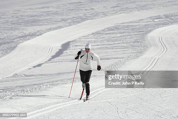 man cross country skiing on glacier - langlaufski stock-fotos und bilder