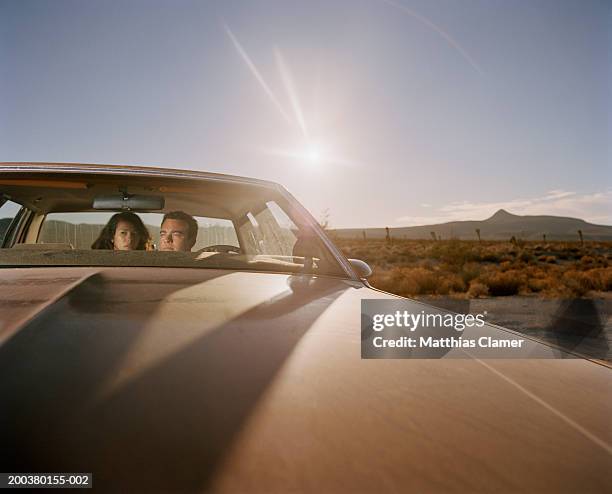 sun shinning behind couple in car, close-up - sun flare couple stock-fotos und bilder