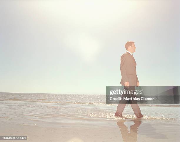 businessman walking through surf, side view - ankle deep in water stock pictures, royalty-free photos & images