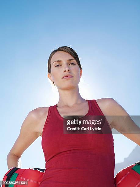 woman wearing boxing gloves, hands on hips, portriat, low angle view - boxing womens stock pictures, royalty-free photos & images