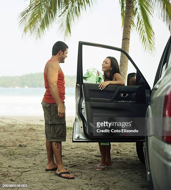 couple talking by car at beach - playa carrillo stock-fotos und bilder