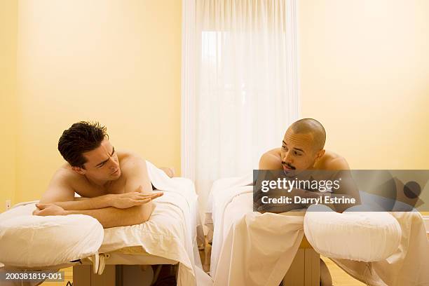 two men lying on massage tables - banc de massage photos et images de collection