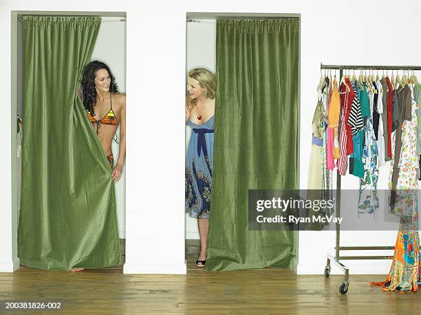 two young female models in dressing rooms, smiling at one another - backstage photography stock-fotos und bilder