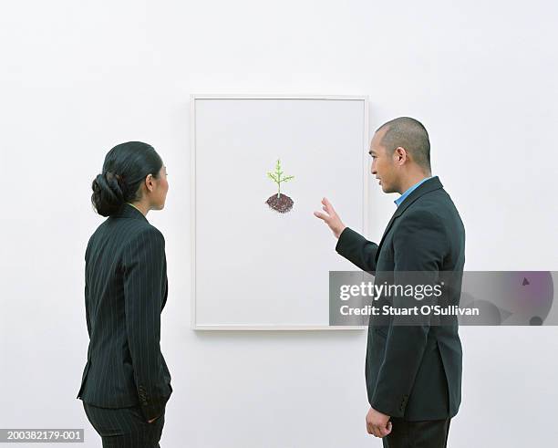 man showing woman picture in art gallery - gallery 2 stock pictures, royalty-free photos & images