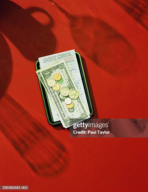 restaurant bill on small tray, cash piled on top - rechnung restaurant stock-fotos und bilder