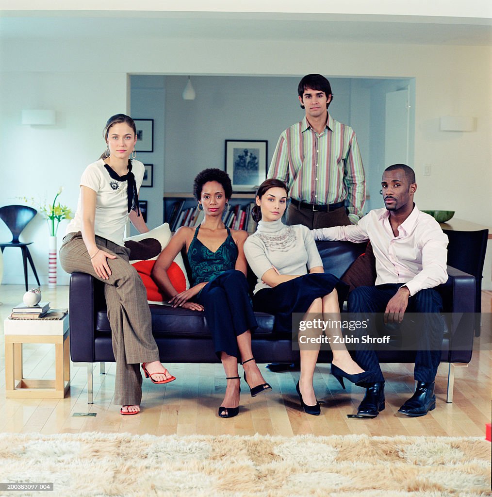 Group of people on sofa in living room, portrait