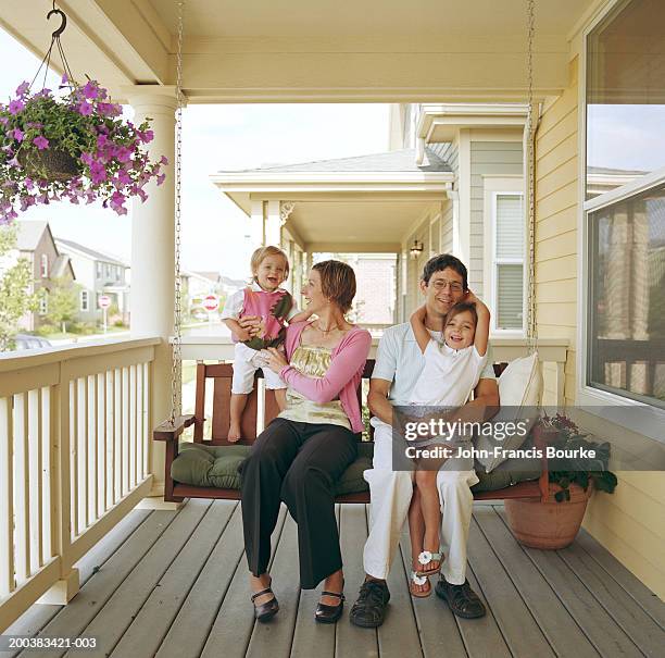 parents and daughters (21 months to 5) sitting on porch - swing chair stock pictures, royalty-free photos & images