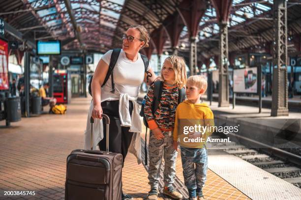 family with bags at copenhagen train station - railroad station stock pictures, royalty-free photos & images