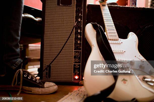 male standing beside electric guitar and amplifier, low section - guitar amp stock pictures, royalty-free photos & images