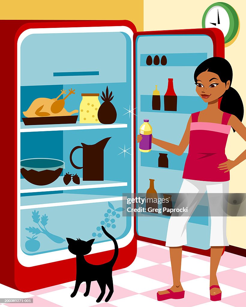 Woman and cat looking inside refrigerator