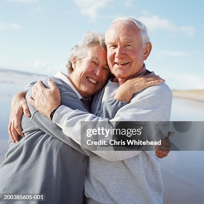 Senior couple embracing on beach, smiling, portrait Senior couple embracing on beach, smiling, portrait