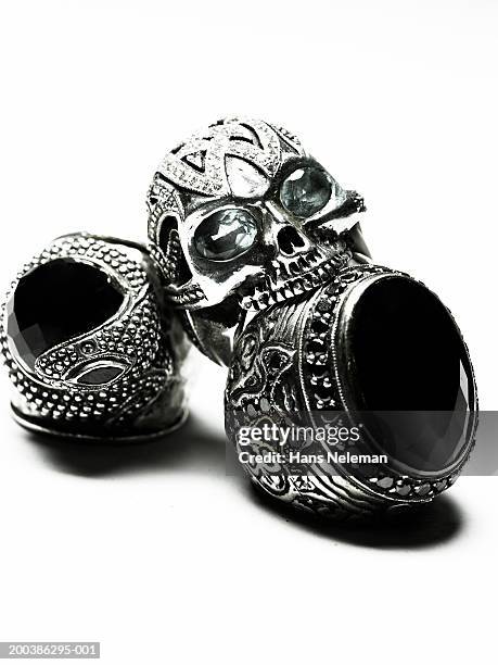 skull-shaped ring on top of two rings with black stone, close-up - rebel skull stock pictures, royalty-free photos & images