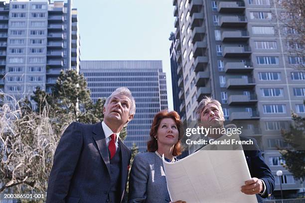 three executives with blueprints on urban sidewalk, looking up - san francisco design center stock pictures, royalty-free photos & images