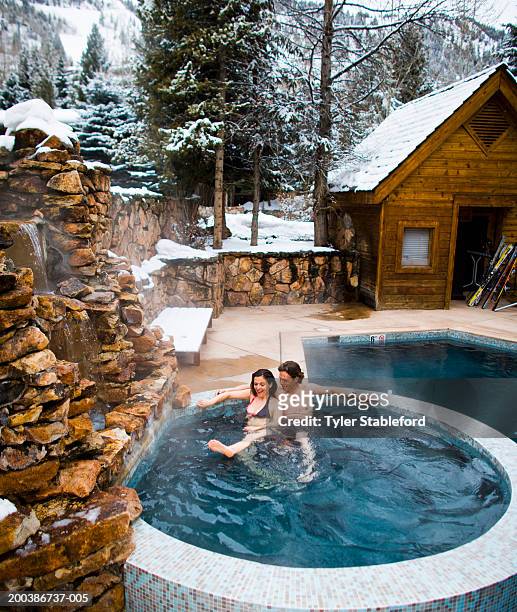 mature couple, sitting in outdoor hot tub, relaxing, elevated view - mature couple winter outdoors stockfoto's en -beelden