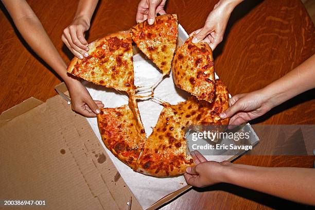 people grabbing slices of pizza, overhead view - pizza share bildbanksfoton och bilder