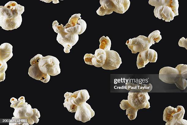 popcorn on black background - popcorn stock pictures, royalty-free photos & images