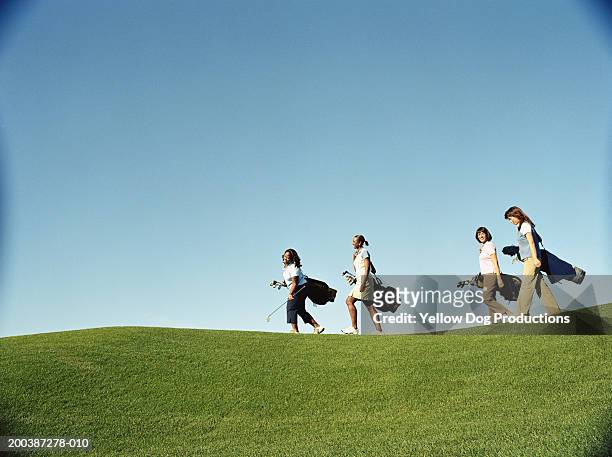female golfers carrying golf bags, side view - golfer stock pictures, royalty-free photos & images