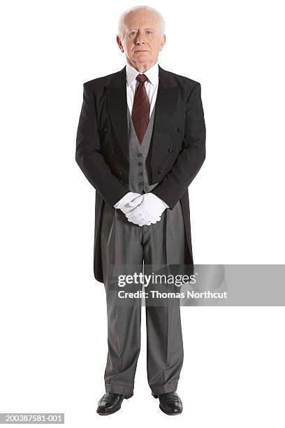 senior male butler, hands clasped, portrait - maggiordomo foto e immagini stock