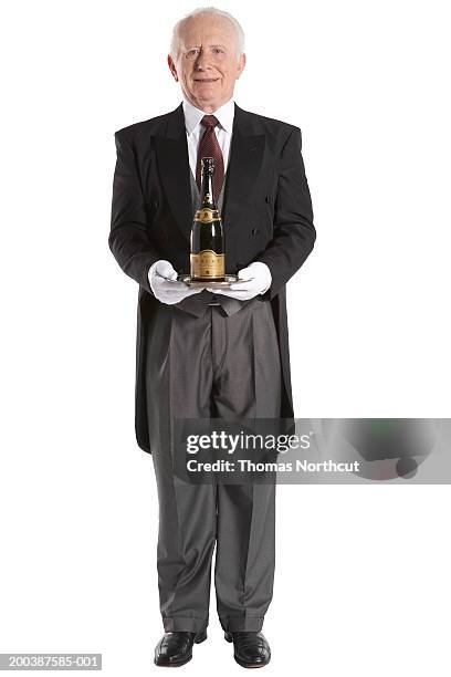 senior male butler carrying bottle of champagne, smiling, portrait - frack bildbanksfoton och bilder