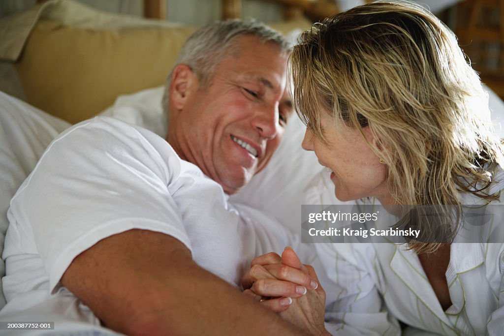 Senior couple smiling in bed, close-up