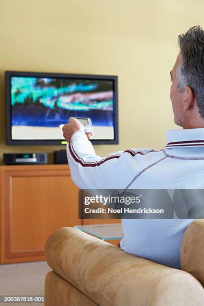 mature man using television remote control, rear view - man rear view grey hair closeup stock pictures, royalty-free photos & images