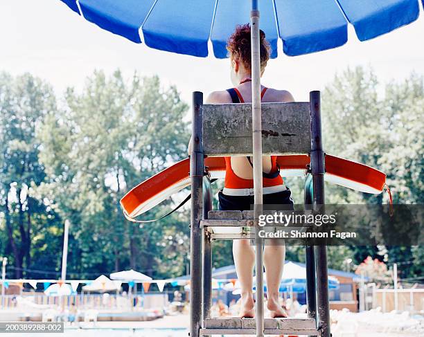 teenage female lifeguard (14-16) watching pool, rear view - lifeguard stock pictures, royalty-free photos & images