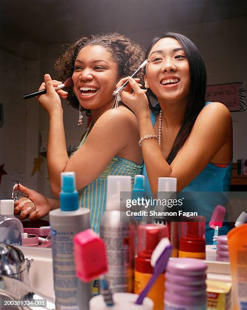 teenage girls (18-20) applying make-up in bathroom - friends women makeup stockfoto's en -beelden