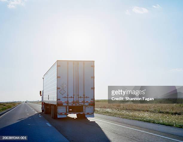 truck traveling on highway, rear view, sunset - mezzo di trasporto foto e immagini stock