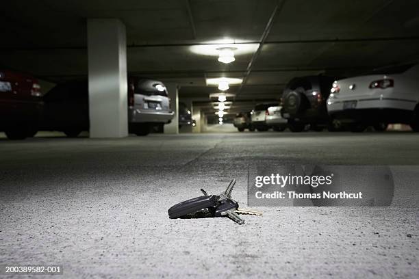 car keys on concrete in parking garage (focus on car keys) - lost car keys stock pictures, royalty-free photos & images