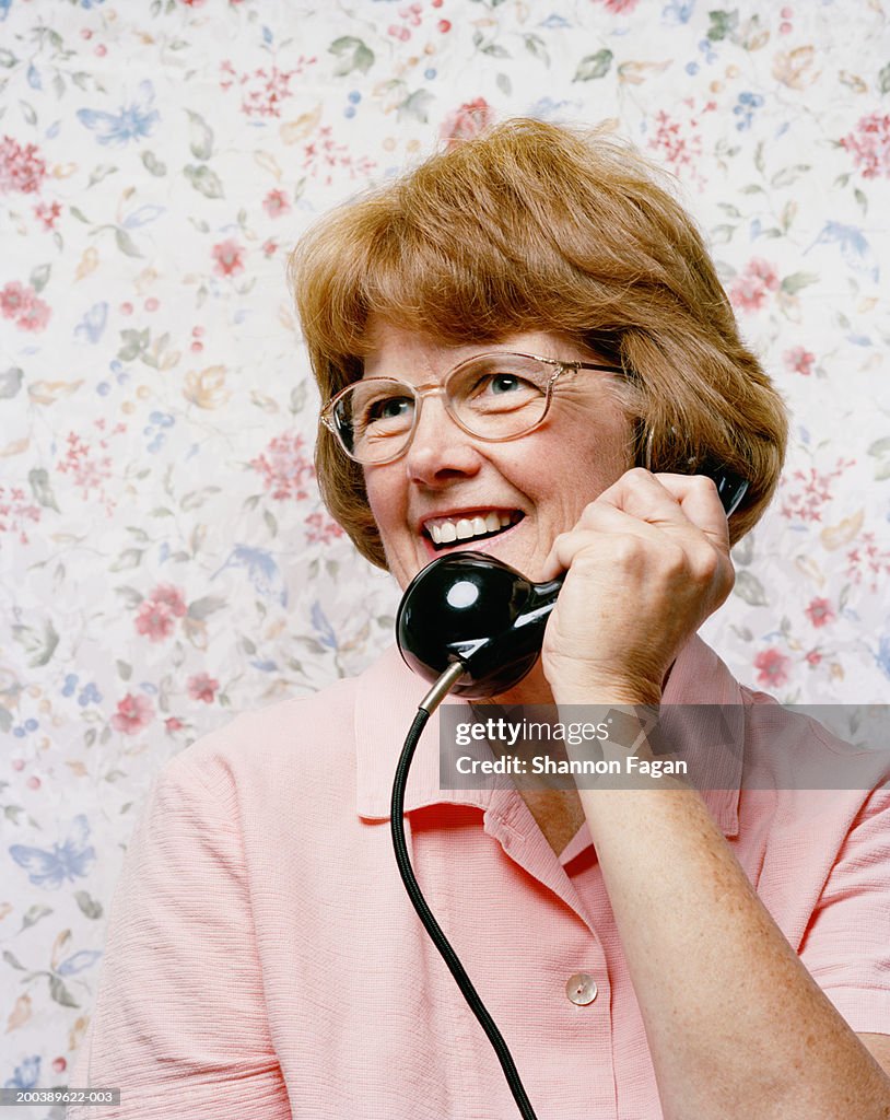 Mature woman using landline telephone