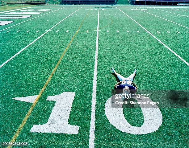 football player stetching on 10 yard line, elevated view - number 10 stock pictures, royalty-free photos & images