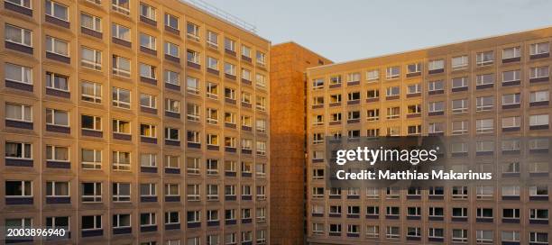 berlin city symmetry plattenbau residential building with shadow and sun light mix - wohnungsprobleme stock-fotos und bilder