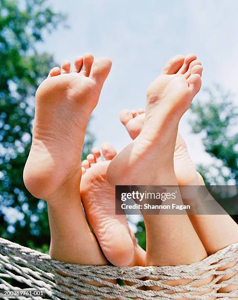 young women lying in hammock, low section, close-up of feet - bottom of feet foto e immagini stock