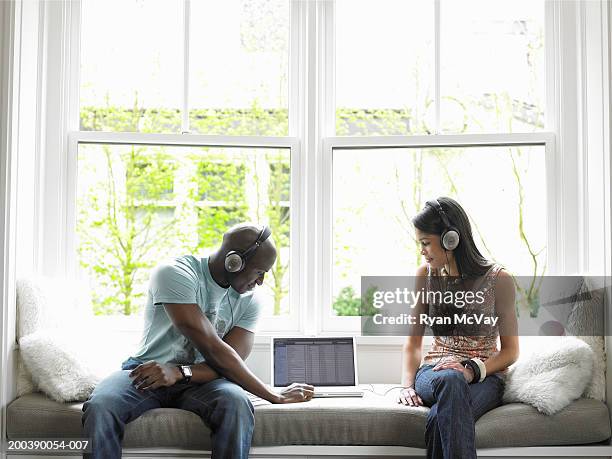 young man and teenage girl (15-17) listening to music on laptop - baladeur mp3 photos et images de collection