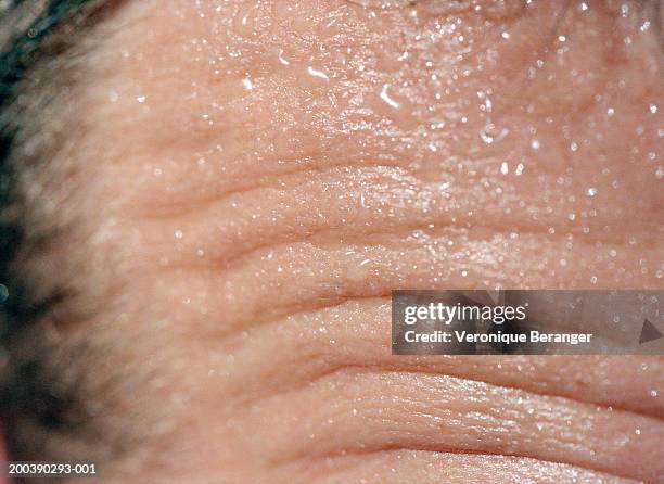 close-up of man's wrinkled forehead - sudor fotografías e imágenes de stock