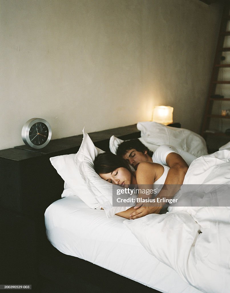 Teenage couple (16-19) sleeping in bed