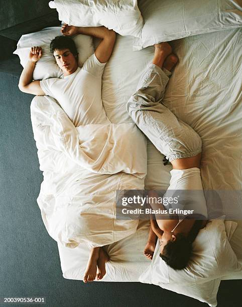 teenage couple (16-19) sleeping in bed, overhead view - above view of man sleeping on bed stock-fotos und bilder