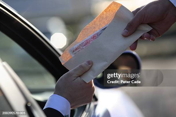 money being handed over from car, close-up - corruption stock pictures, royalty-free photos & images