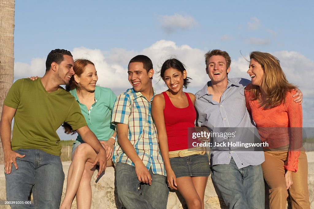 Group of people leaning against a wall