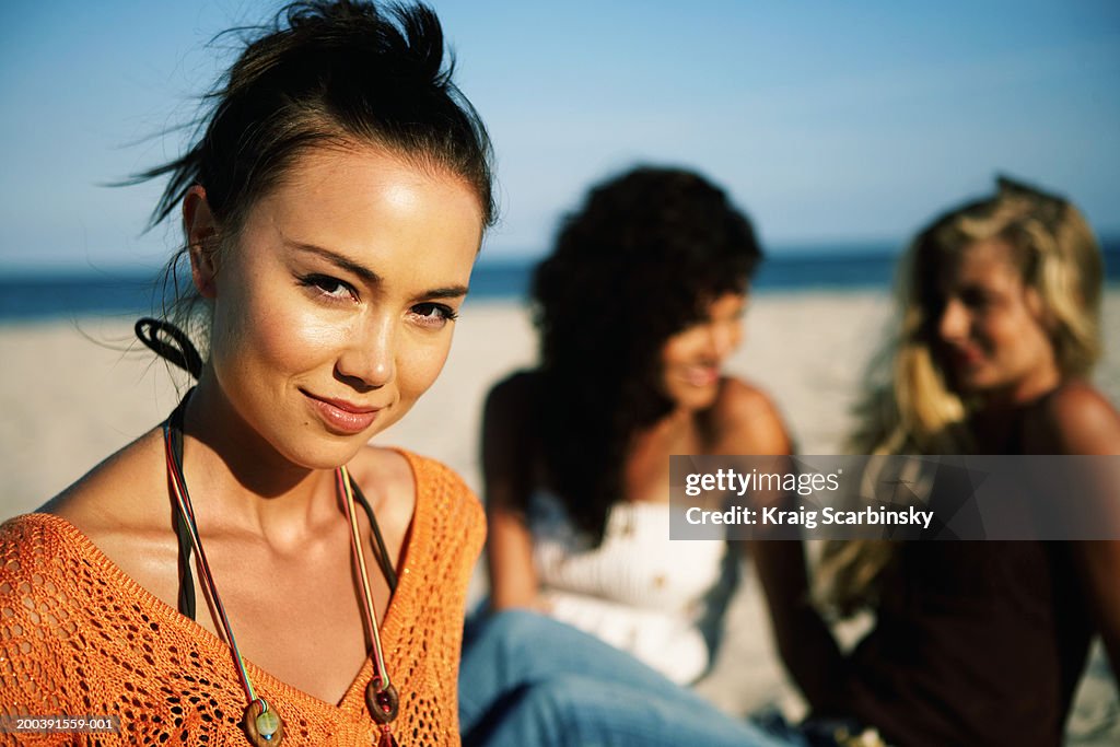 Young woman smiling on beach, portrait, close-up