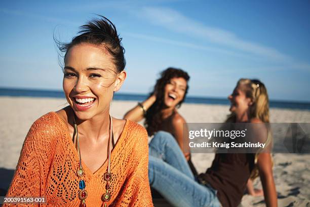 young women smiling on beach, portrait, close-up (focus on foreground) - depth of field togetherness looking at the camera stock pictures, royalty-free photos & images