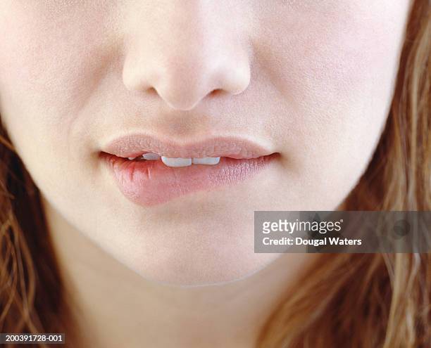 young woman biting lip, close-up - female biting lips stockfoto's en -beelden