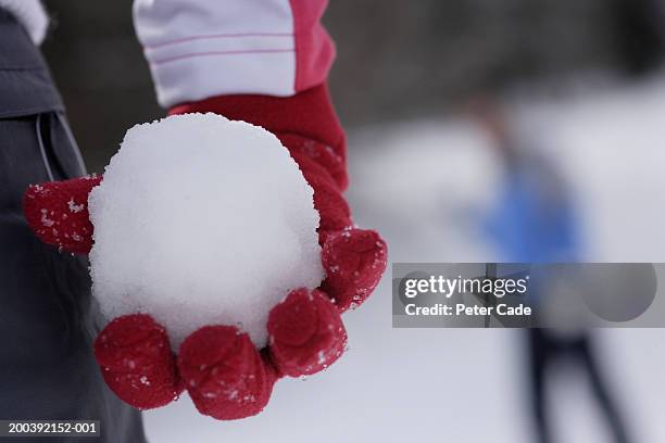 woman holding a snowball, mid section, close-up - snowball stock pictures, royalty-free photos & images