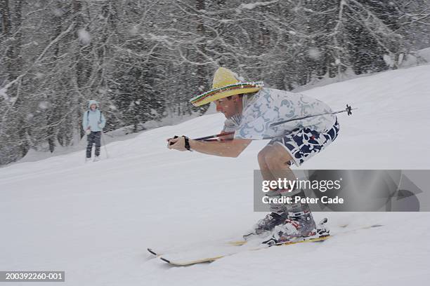 man in summer clothing and sombrero skiing, side view - funny snow skiing fotografías e imágenes de stock