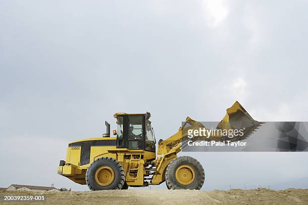 construction worker in cab of bulldozer - baumaschine stock-fotos und bilder