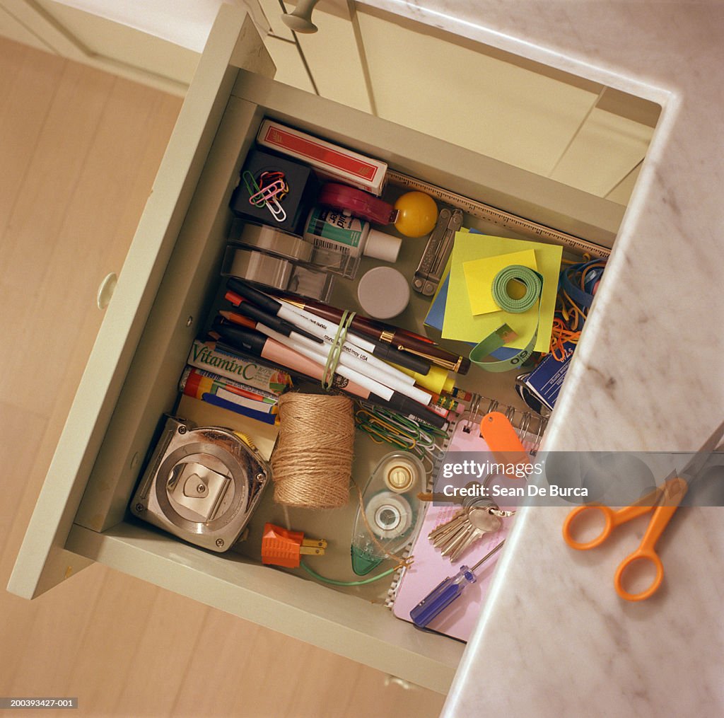 Kitchen drawer containing household items, overhead view