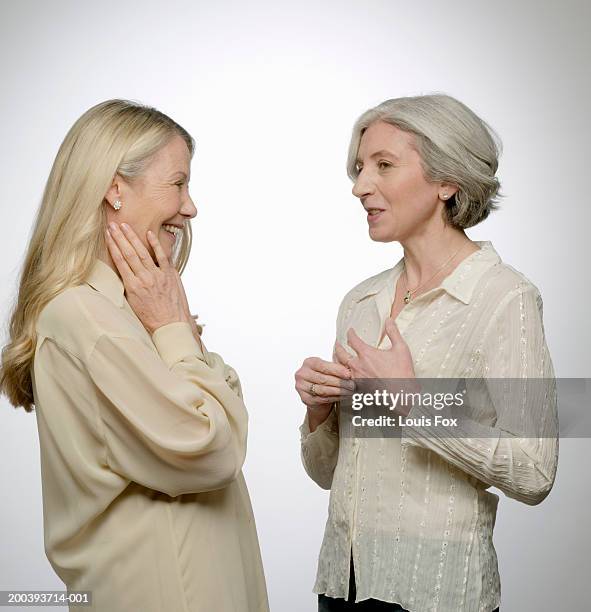 senior woman and mature woman talking, side view - gezicht aan gezicht stockfoto's en -beelden