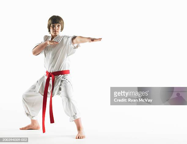 boy (12-14) wearing karate uniform, holding karate pose - teen martial arts stock pictures, royalty-free photos & images