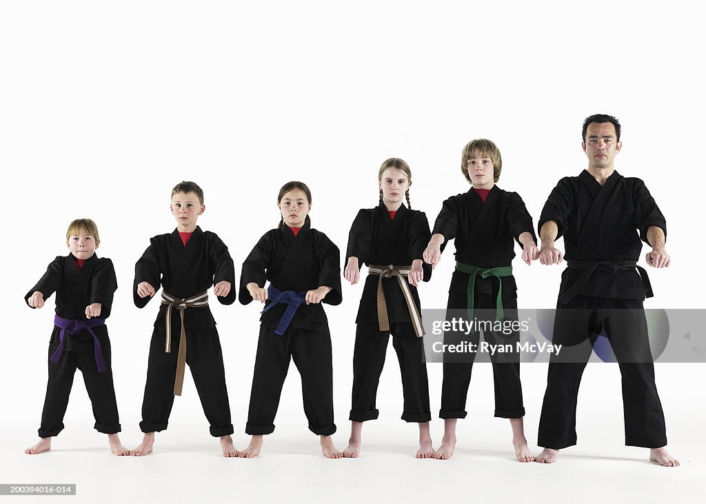 Kempo karate instructor holding karate pose with students